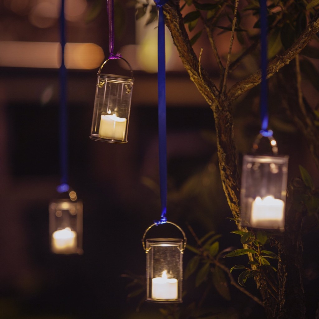 battery-operated candles hanging on trees